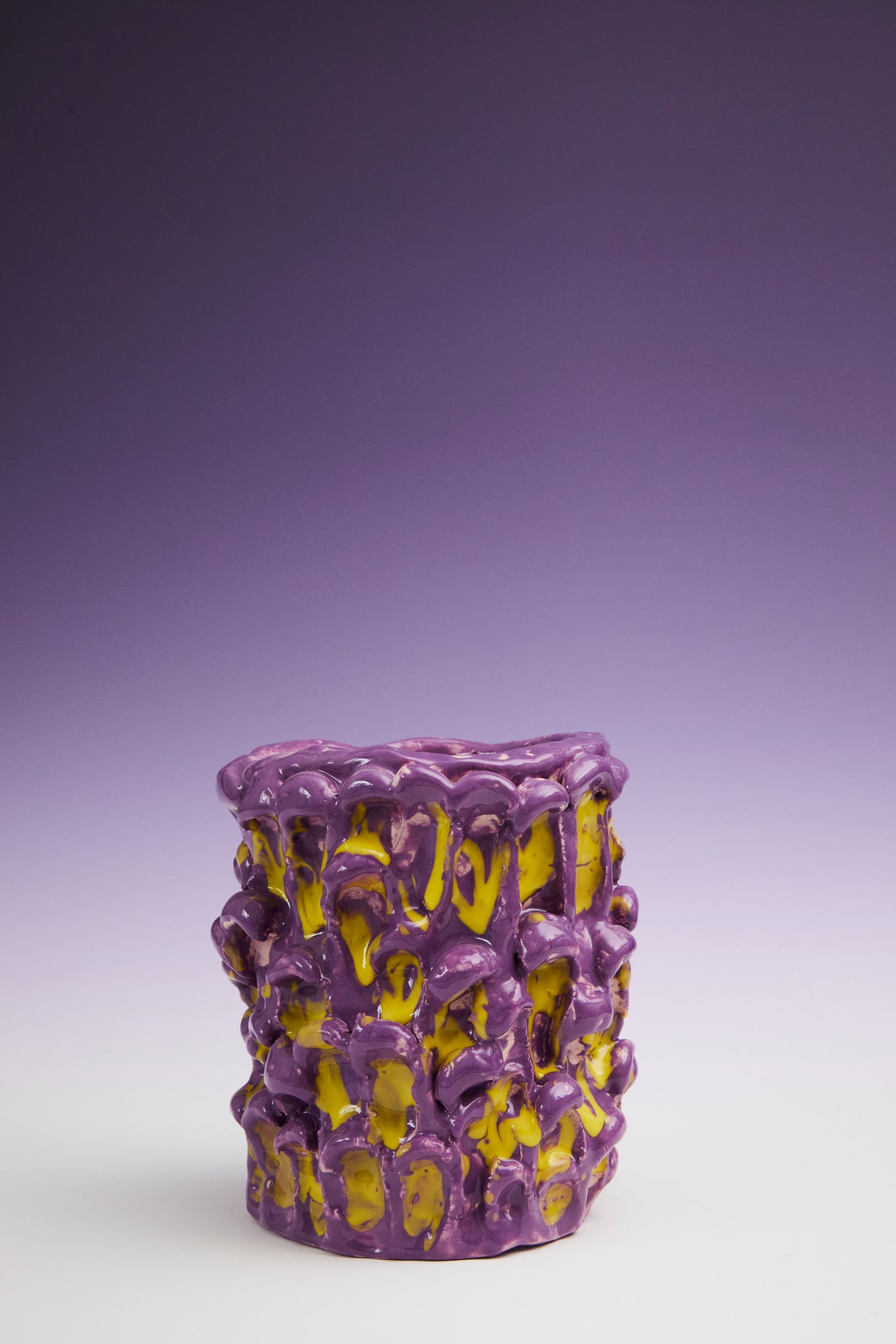 Zoomed-out front view of the Ceramic Vase in Velvet Purple and Lemon Yellow, displayed on a gradient background blending dark purple and white hues.
