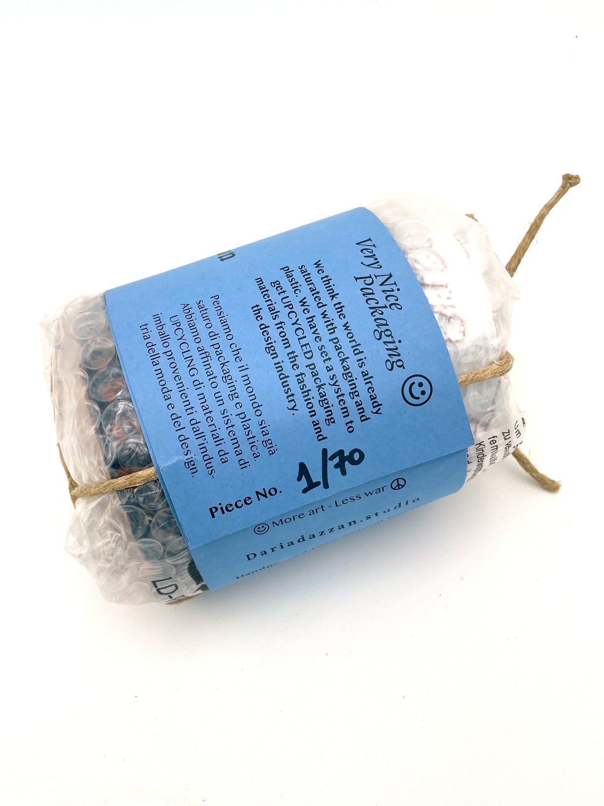 Back view of the Ceramic Pot Candle packaging, featuring a label explaining the upcycled materials sourced from the fashion and design industry, secured with natural cord.