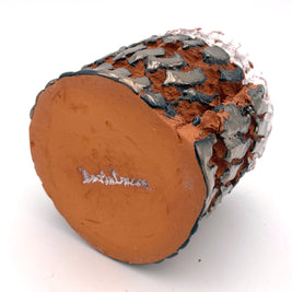 Bottom view of the Ceramic Pot Candle in platinum glaze, showcasing the unglazed base with organic irregularities that emphasize its handcrafted nature, and the author signature.
