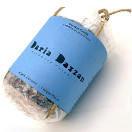 Ceramic Pot Candle wrapped in bubble wrap, secured with a natural cord and branded label showcasing the Daria Dazzan logo.