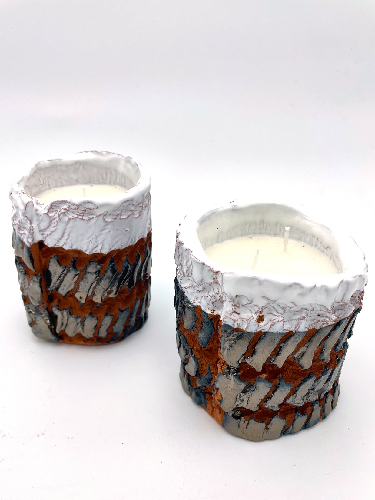 Two Ceramic Pot Candles in platinum glaze displayed side by side, highlighting their unique textured surfaces and artisanal craftsmanship.