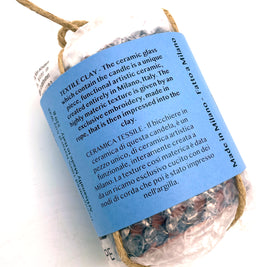 Back view of the Ceramic Pot Candle packaging, with a label describing the textile ceramic process, where the material texture is created by pressing exclusive knotted cord embroidery into clay.
