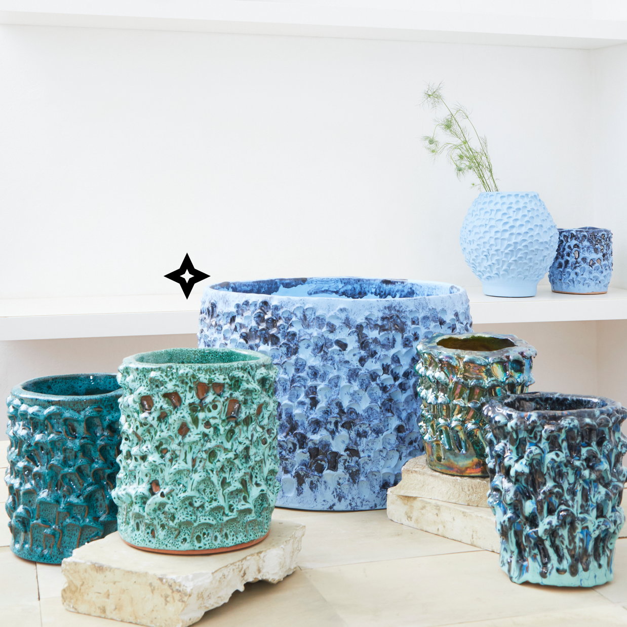 Arrangement of seven Ceramic Vases in Aqua and Aventurine Green hues, showcasing the variety of textures and shapes within the Onda Series, arranged to create an elegant and cohesive display.