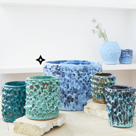 Arrangement of seven Ceramic Vases in Aqua and Aventurine Green hues, showcasing the variety of textures and shapes within the Onda Series, arranged to create an elegant and cohesive display.