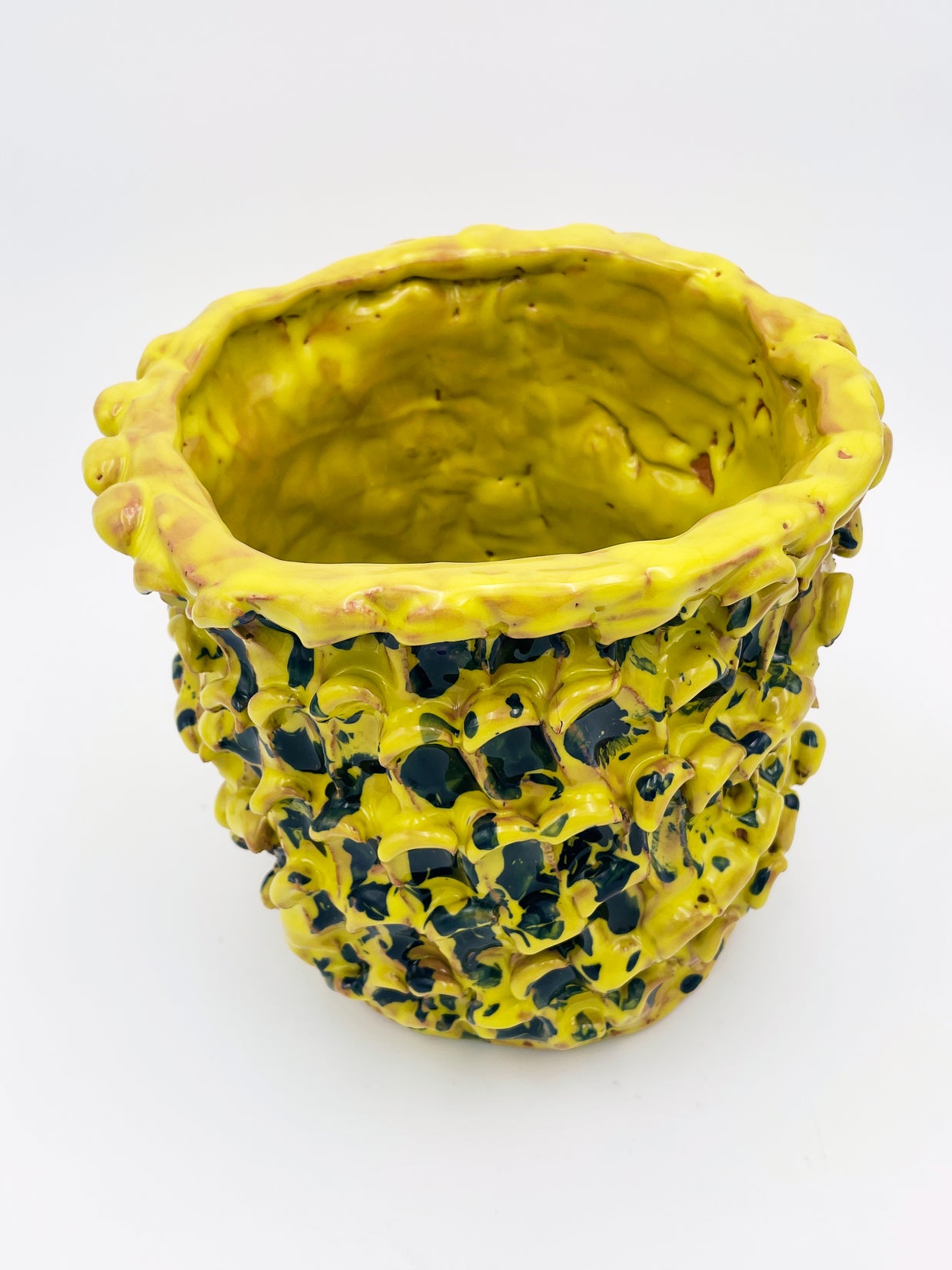 Upper side view of the Ceramic Vase in Cadmium Yellow and Izmir Blue, highlighting the wave-like texture and smooth gradient of colors on a white background.