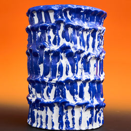 Front view of the Ceramic Vase in Egyptian Blue and White, set against an orange and black gradient background, enhancing its bold and sophisticated aesthetic.