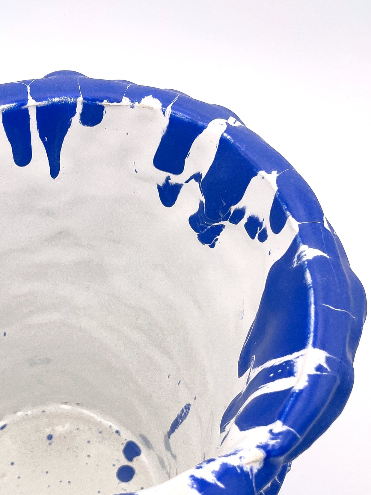 Upper side view of the Ceramic Vase in Egyptian Blue and White, showcasing the smooth interior and organic wave-inspired texture on a white background, with a soft white interior.