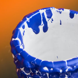 Upper side view of the Ceramic Vase in Egyptian Blue and White, displayed on an orange background, accentuating its smooth lines and glossy finish.