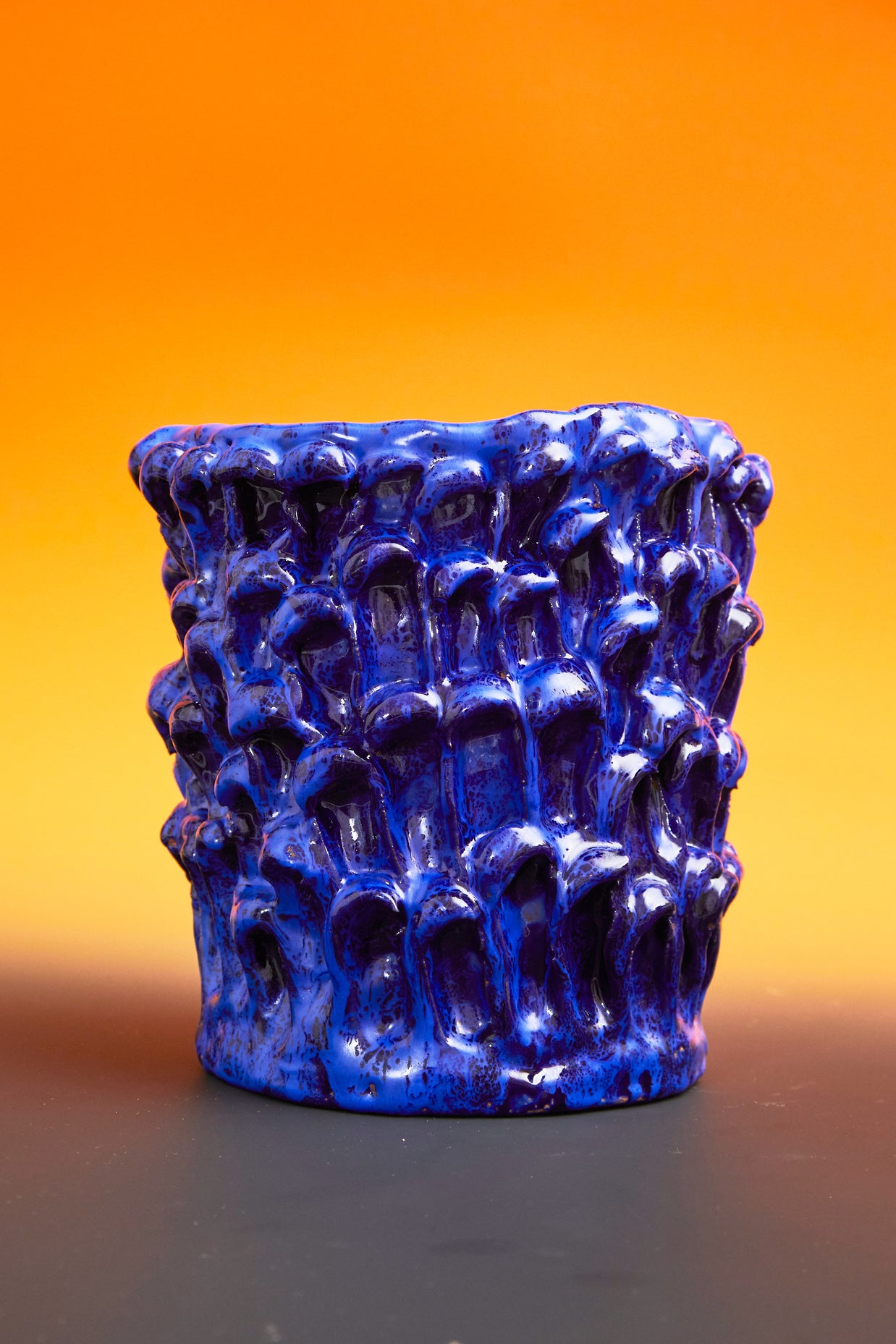 Front view of the Ceramic Vase in Egyptian and Izmir Blue, set against a mustard yellow background, enhancing the contrast and vibrant colors of the glaze.