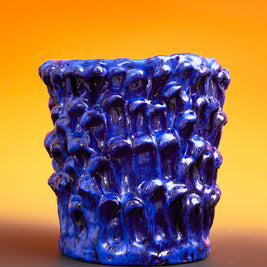 Front view of the Ceramic Vase in Egyptian and Izmir Blue, set against a mustard yellow background, enhancing the contrast and vibrant colors of the glaze.