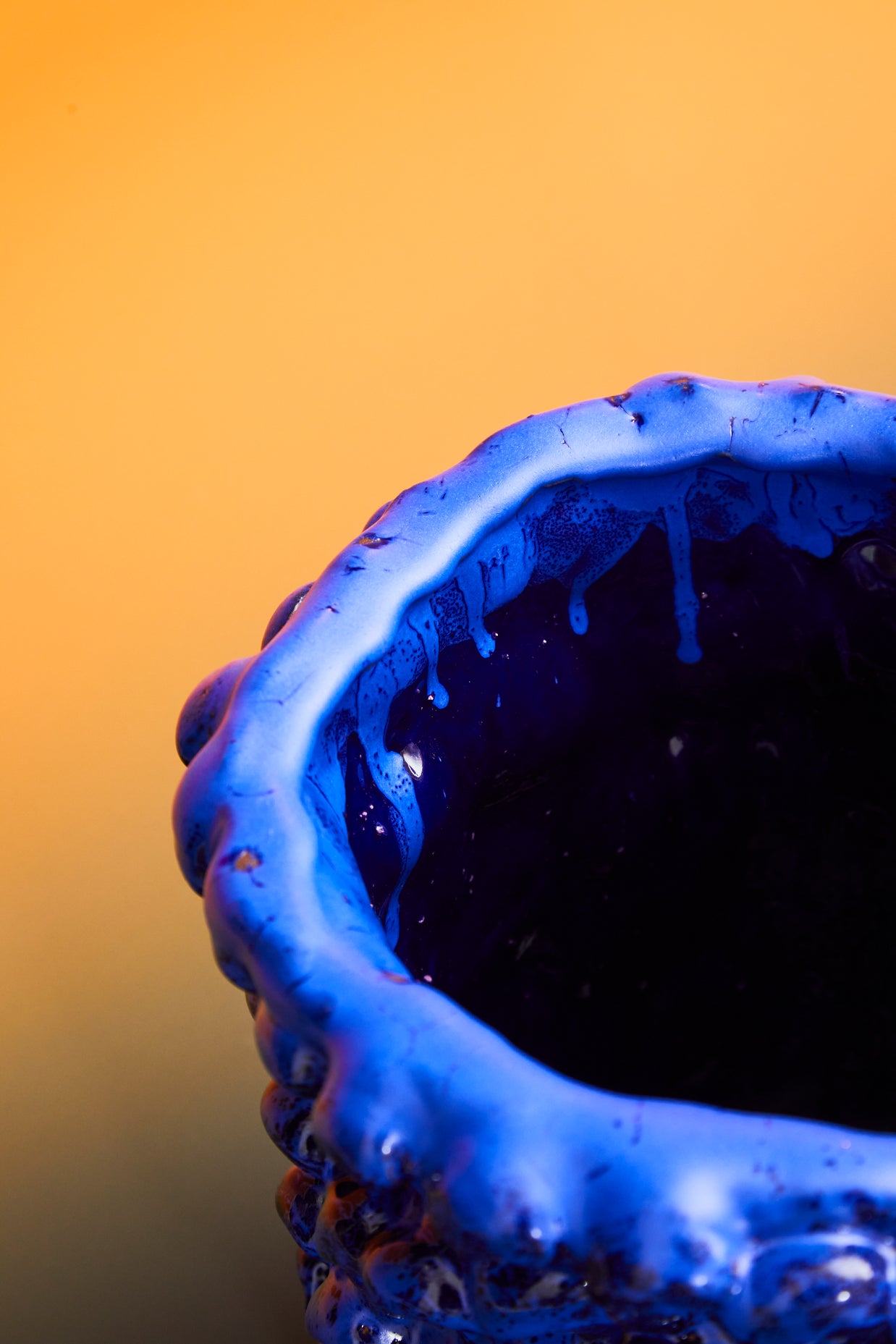 Detail of the upper side of the Ceramic Vase in Egyptian and Izmir Blue, focusing on the textured edge and subtle glaze nuances, set against a mustard yellow background.