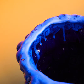 Detail of the upper side of the Ceramic Vase in Egyptian and Izmir Blue, focusing on the textured edge and subtle glaze nuances, set against a mustard yellow background.