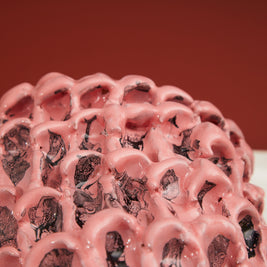 Close-up detail of the Ceramic Vase in Haime Pink and Liquorice, set against a brick-colored background, highlighting its texture and color gradation.