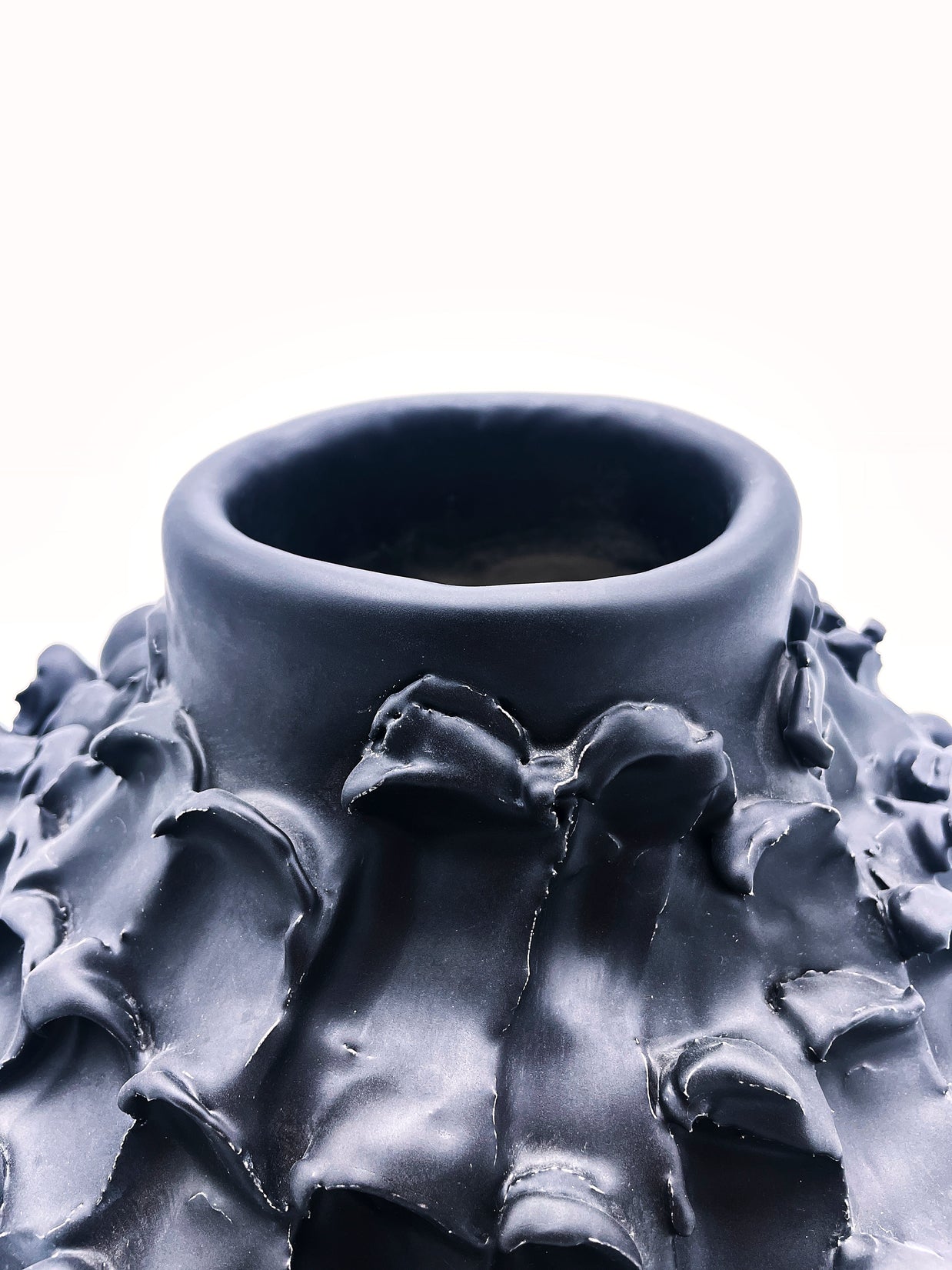 Close-up view of the top of the Ceramic Vase in Licorice Black, focusing on the sleek, narrowed opening and smooth texture of the vase against a white background.