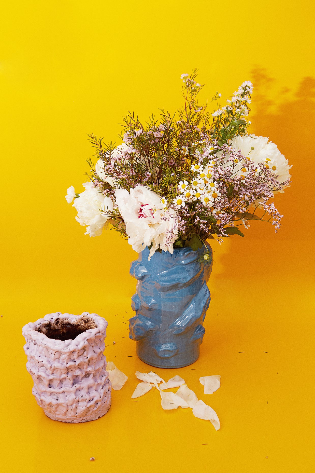 Artistic composition featuring the Ceramic Vase in Lilac Bubble & Chocolate alongside a blue vase with plants, set against a vibrant yellow backdrop.