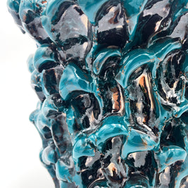 Close-up detail of the Ceramic Vase in Metallic Biscay Bay, highlighting the wave-like texture and the glossy metallic reflections.