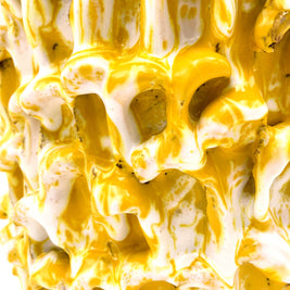 Close-up of the Ceramic Vase in Metallic Mineral Blush, highlighting the interplay of yellow and white in its textured surface.