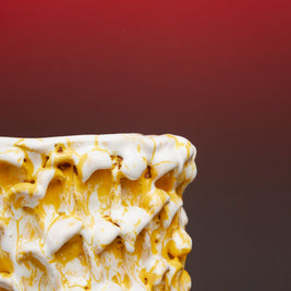 Close-up of the side border of the Ceramic Vase in Metallic Mineral Blush, showing its reflective finish against a gradient background transitioning from black to red.