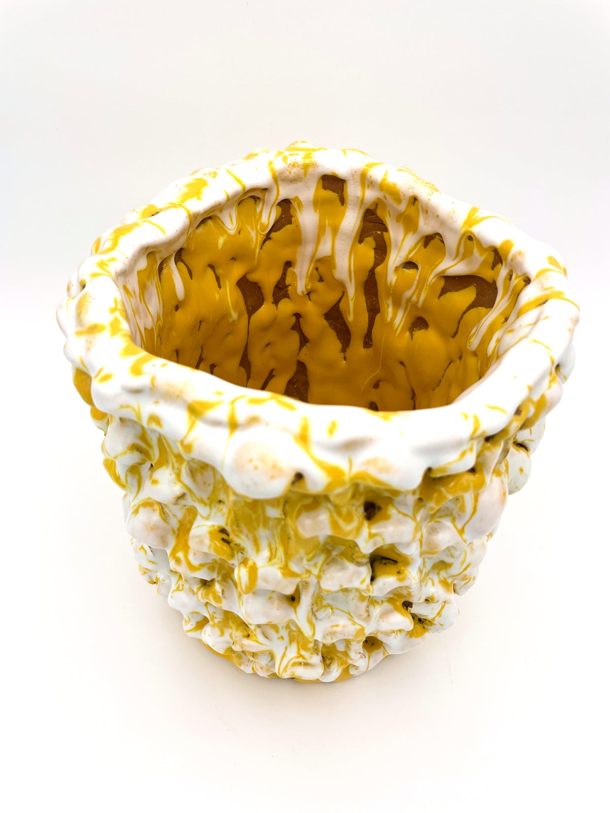 Top diagonal view of the Ceramic Vase in Metallic Mineral Blush, offering a glimpse of the interior and its intricate yellow and white texture with some neutral inserts.