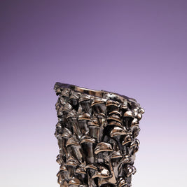 Front view of the Ceramic Vase in Metallic Platinum, set against a gradient background transitioning from white at the bottom to violet at the top.