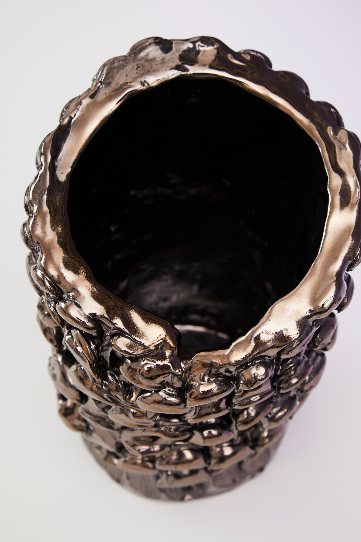 Top view of the Ceramic Vase in Metallic Platinum, capturing the warm coppery reflection on its surface under specific lighting.