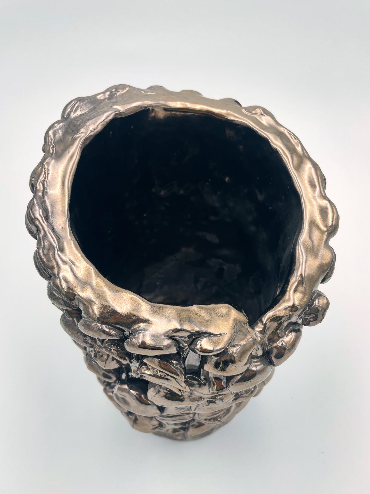 Top view of the Ceramic Vase in Metallic Platinum, emphasizing the silvery reflection on its surface with shifting light angles.