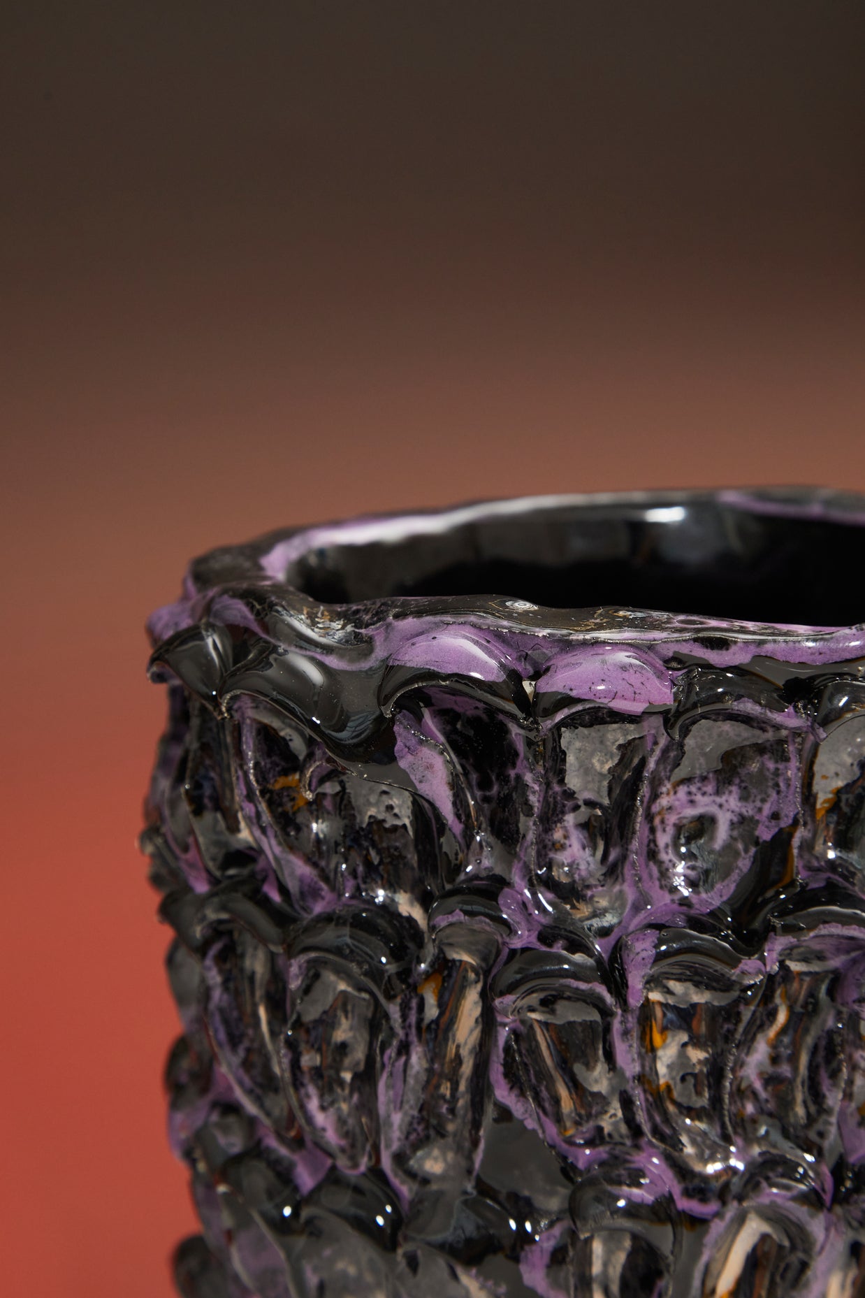 Close-up detail of the Ceramic Vase in Metallic Purple with a gradient backdrop transitioning from deep red to black.