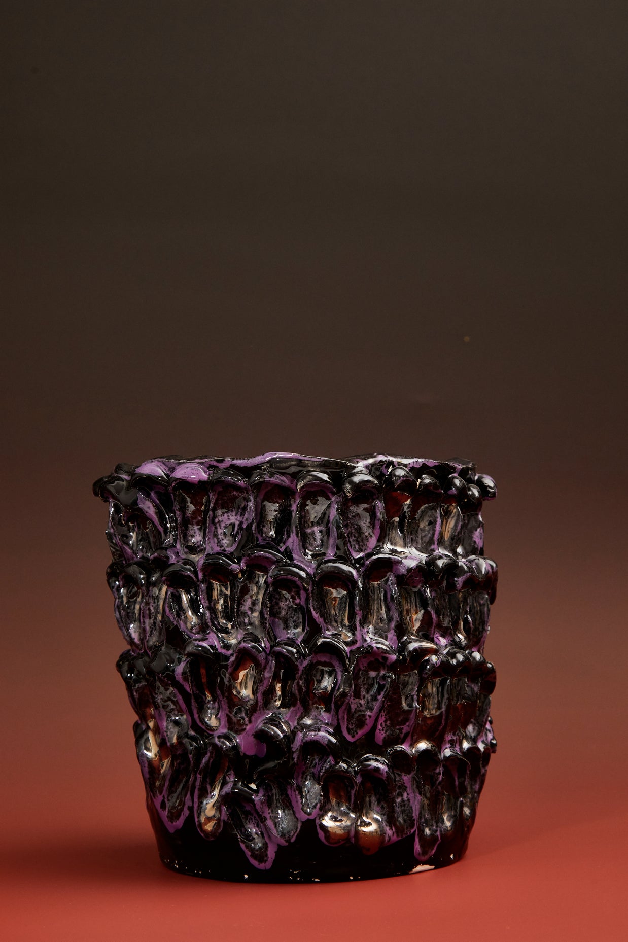 Front view of the Ceramic Vase in Metallic Purple against a gradient background transitioning from deep red at the base to black at the top.