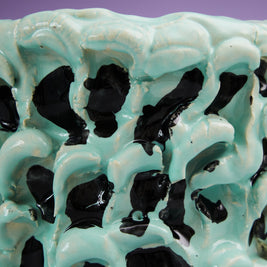 Close-up view of the upper edge of the Ceramic Vase in Tiffany and Pitch Black, showcasing the smooth contours and black wave insert details, set against a purple background.
