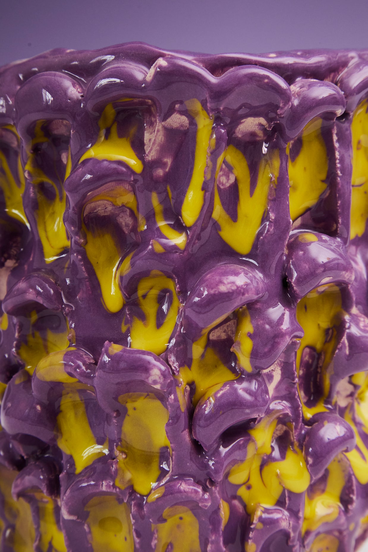Close-up detail of the Ceramic Vase in Velvet Purple and Lemon Yellow, showing its delicate texture and intricate yellow drip pattern, on a gray background.