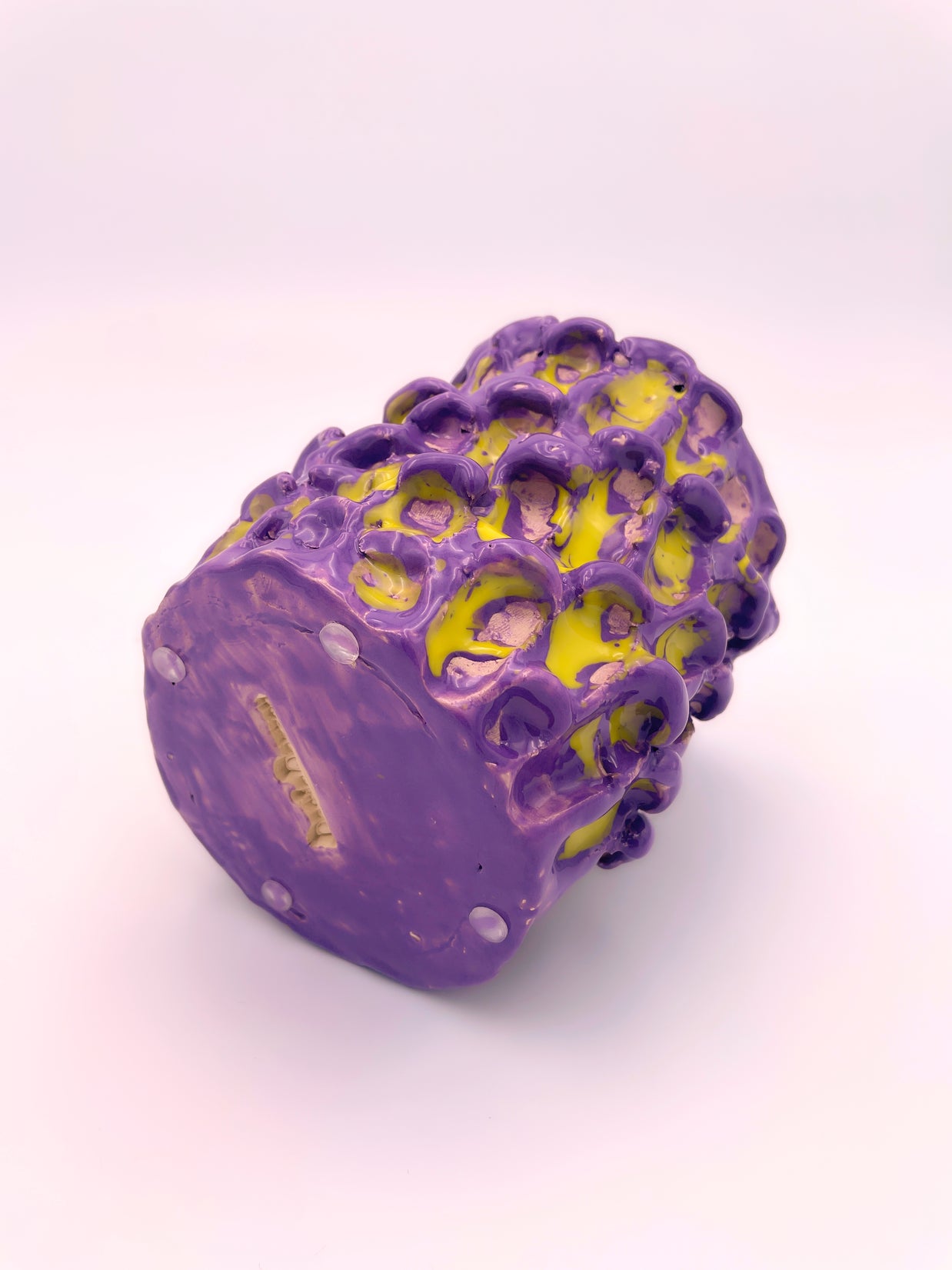 Horizontal view of the Ceramic Vase in Velvet Purple and Lemon Yellow, with a light pink background, highlighting its unique color combination and design and the author's signature.