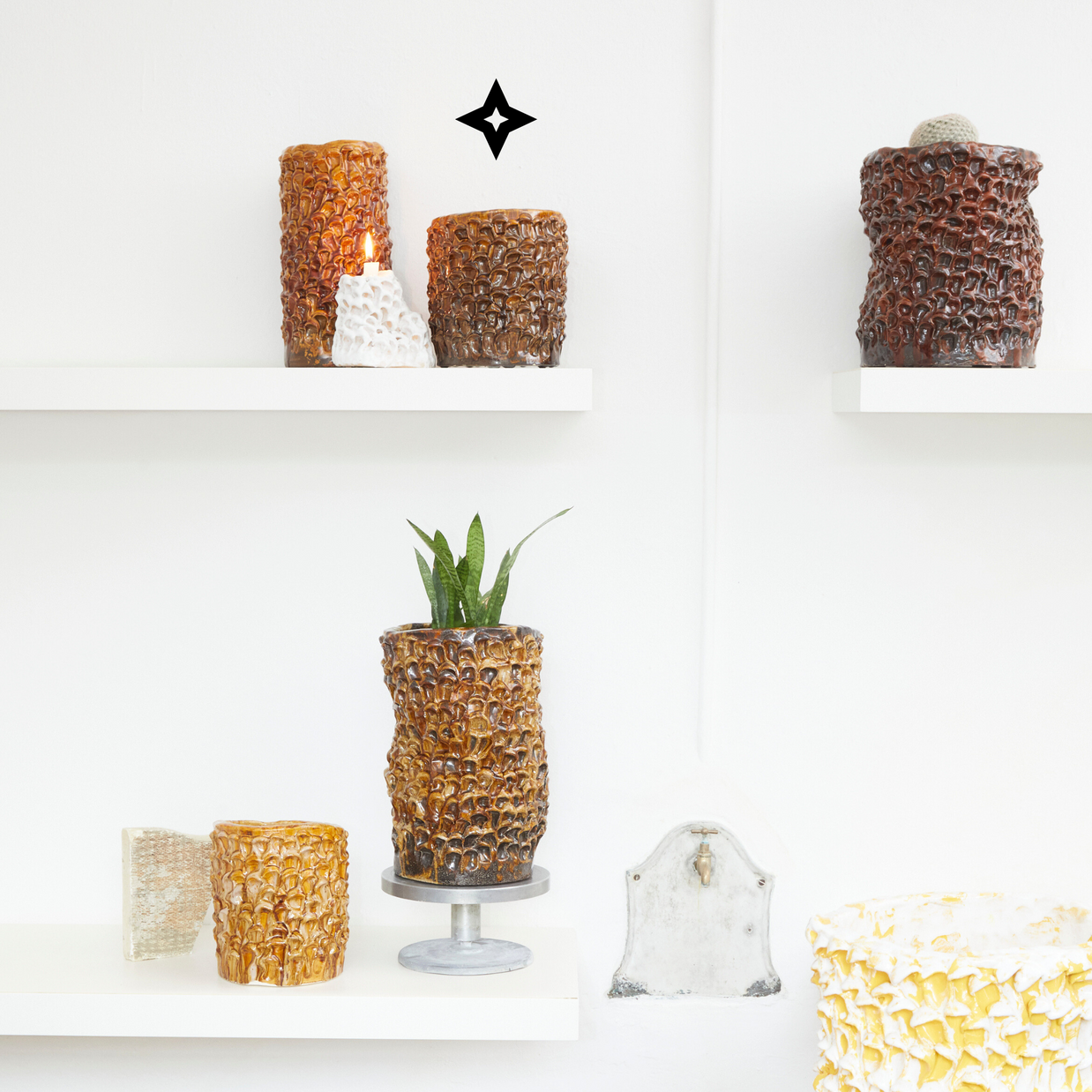 Indoor composition featuring Ceramic Vases in Translucent Honey on different shelves, surrounded by plants and decor elements, showcasing the vases' versatility in home interiors.